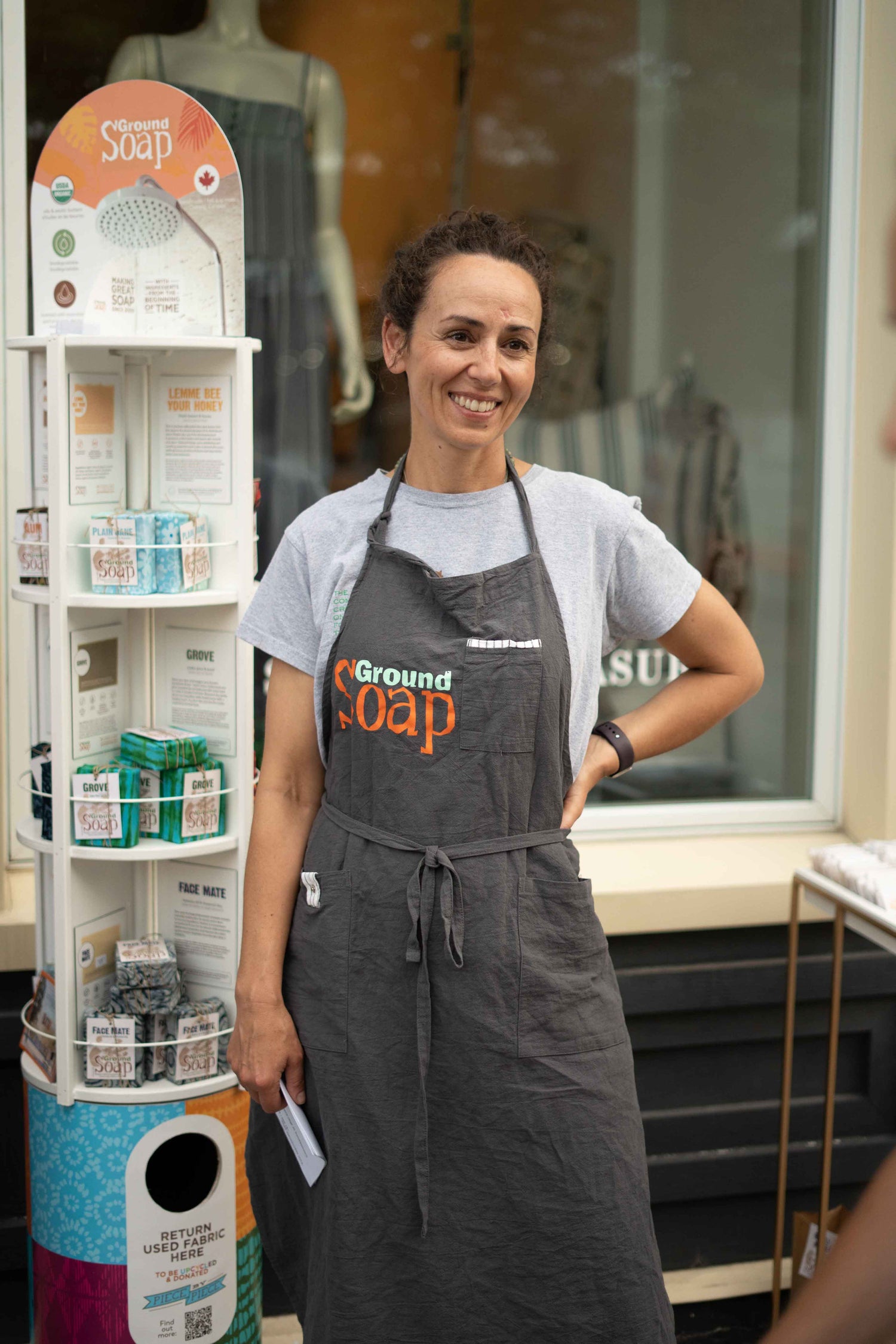 Angela Youngs, the founder of Ground Soap, standing next to her store display