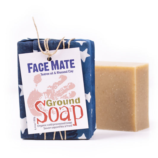 One wrapped and one naked bar of Face Mate Teatree essential oil and rhassoul clay organic bar soap from ground Soap.