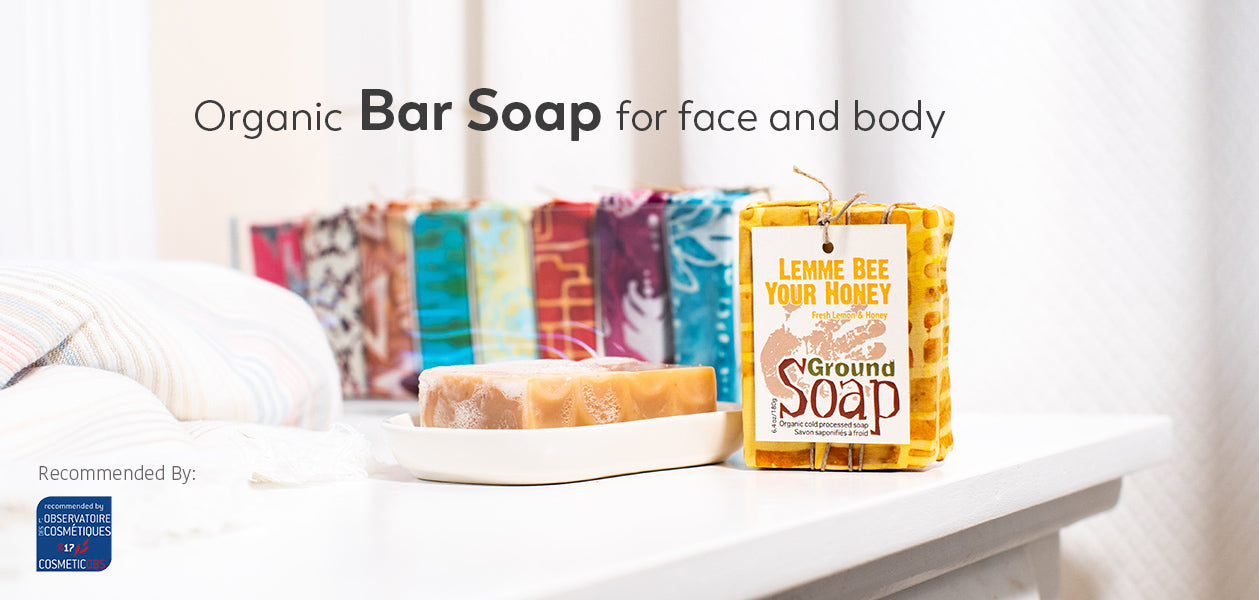 Ground Soap organic bar soap wrapped on a counter with a bathroom scene.