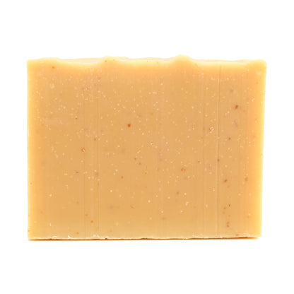 A naked bar of Lemme Bee Your Honey lemon essential oil and honey organic bar soap from Ground Soap.